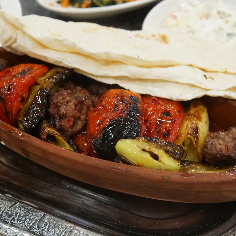 Toprak kapta tereyağlı Urfa kebap, közlenmiş domates, biber ve lavaş